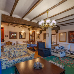 Salón con 3 sillos y un comedor detrás