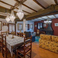 Salón con una mesa de comedor y una zona con sillones y una chimenea
